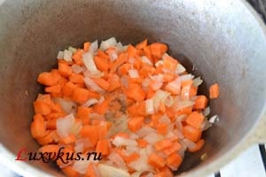 До цибулі додати моркву і тушкувати на невеликому вогні 1-2 хвилини